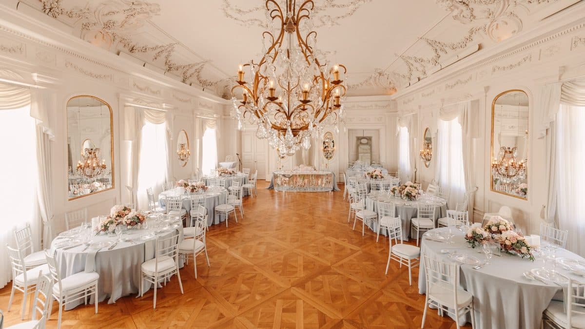 Festsaal mit langer Tafel, goldenen Kerzenständern und Kronleuchter