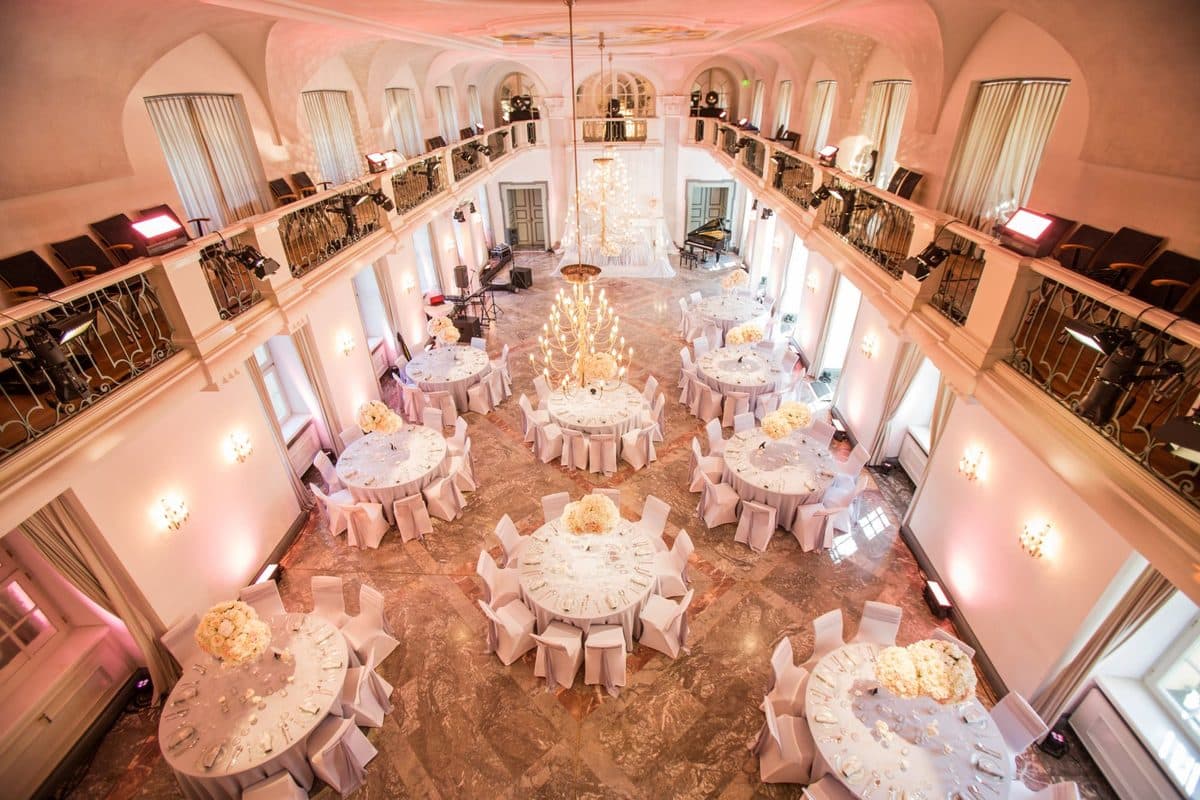 Festsaal mit zwei Emporen, Deckenfresko und runden Hochzeitstischen von oben fotografiert