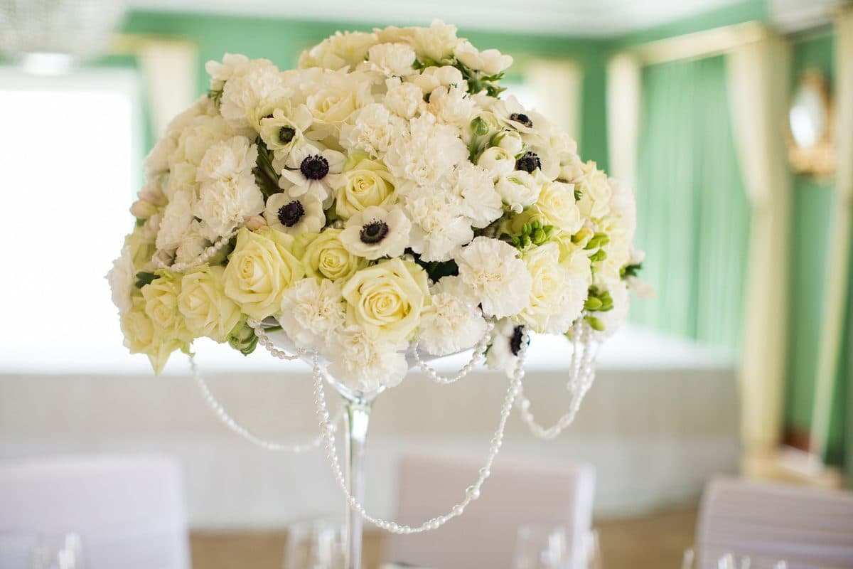 Detailaufnahme hohes Blumengesteck aus weißen Rosen mit Perlenketten