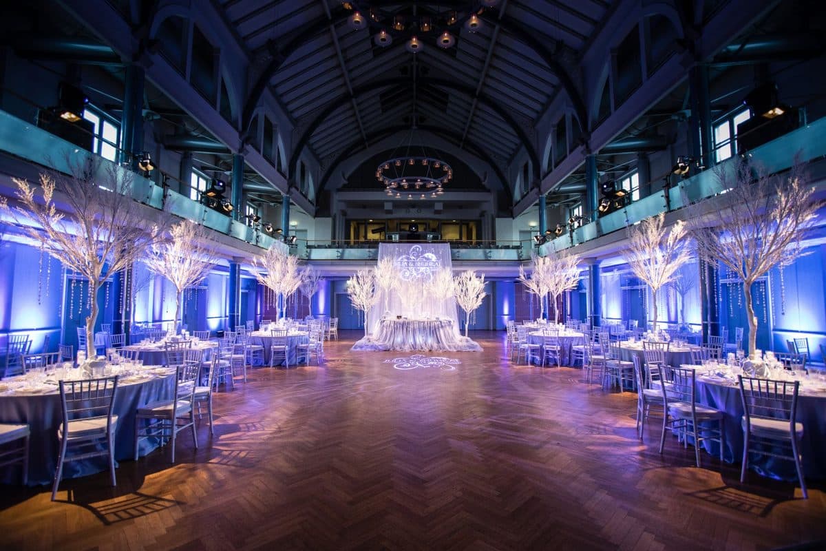 Festsaal mit weißen Winterbäumen, Kristallketten und rundem Kronleuchter in Blau