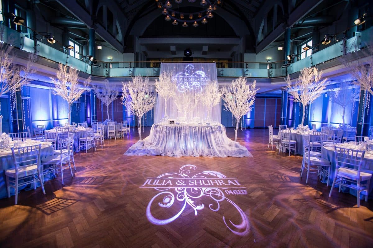 Festsaal mit Bogendach, weißen Winterbäumen und blauer Lichtstimmung