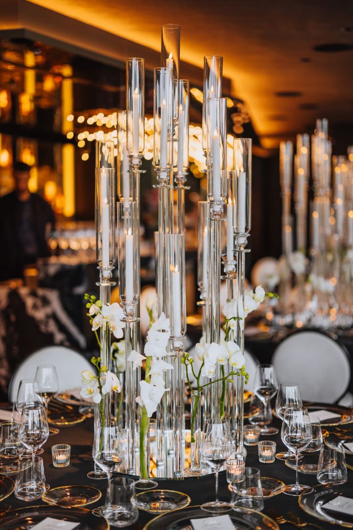 Detailaufnahme hoher Glas-Kerzensäulen mit weißen Orchideen